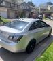 A silver 2011 Chevrolet Cruze parked on the street with black wheels and tinted windows