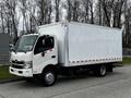 A white 2013 Hino 195 box truck with a large cargo area and red striping on the side