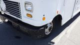 A white 2011 Ford Econoline with a distinctive front design featuring horizontal grilles orange indicator lights and a black bumper with noticeable scratches