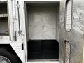 An open compartment of a 2006 GMC C5000 with metallic walls and a black floor, showcasing a spacious interior without any items inside