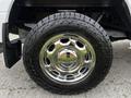 A chrome wheel with a rugged tire of a 2016 Ford F-150 showing a shiny finish and bold tread pattern