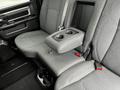 Interior view of a 2021 RAM 1500 Classic showing the backseat with a folding armrest and cup holders between two fabric-covered seats