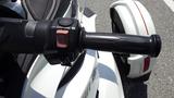 A close-up view of the handlebar grip of a 2013 Can-Am Spyder showcasing the throttle grip and control buttons