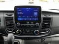 A 2021 Ford Transit dashboard featuring a large touchscreen display with audio and climate controls along with various buttons and knobs