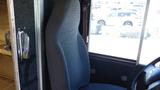 A gray cloth driver's seat in a 2006 Ford Econoline van with a steering wheel and interior panel visible