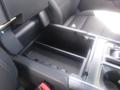 A 2022 Ford F-150 center console with an open storage compartment and a section for cup holders