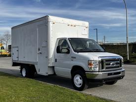 A white 2013 Ford Econoline box truck with a closed cargo area and a flat front design parked on a street