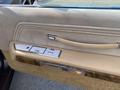 Interior door panel of a 1982 Mercury Grand Marquis featuring beige upholstery and chrome accents with window controls and a door handle