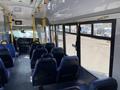 Interior of a 2017 Chevrolet Express bus featuring rows of blue seats and a driver's area visible at the front