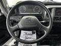 Steering wheel and dashboard of a 2019 Hino 338 with gauges and controls visible along with a floor mat that says Thank You