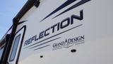 A close-up of a 2021 Grand Design Reflection recreational vehicle with the brand name prominently displayed on the side