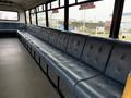 A 2011 Ford F-550 with a long blue upholstered bench seat inside the cabin designed for passenger transport