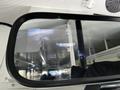 A side mirror of a 2022 Blue Bird Vision displaying a view from a camera with a white vehicle visible on the screen