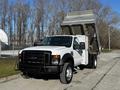 2008 Ford F-450 SD with a dump bed raised and open displaying a sturdy white body and black grille