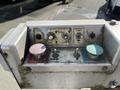 A control panel featuring buttons for speed, platform control, emergency power, and rotation with visible wear and grime