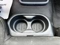A close-up view of the center console in a 2010 Ford Ranger showing two circular cup holders with vertical slits