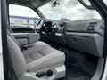 Interior view of a 2007 Ford F-550 truck showcasing the driver's seat dashboard and control panel with light gray fabric seats and a spacious cabin