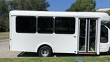 A white 2011 Chevrolet Express bus with large windows and a wheelchair-accessible entrance