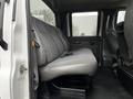 A gray cloth bench seat inside a 2005 GMC C5 Duramax truck with adjustable seatbelts and door controls visible on the side