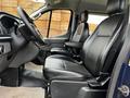 Interior view of a 2020 Ford Transit showing black leather seats and a steering wheel with controls on the dashboard