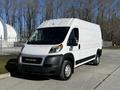 A white 2019 RAM Promaster van parked with its front angled toward the viewer featuring large headlights and a prominent grille with the RAM logo