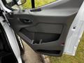 A close-up of the driver's side door panel of a 2020 Ford Transit featuring armrest and storage compartment