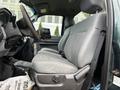 A gray leather seat in the cabin of a 2012 Ford F-550 showing the driver's side with a gear shift and dashboard controls visible