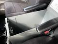 Interior view of a 2011 Dodge Grand Caravan showing a central console with a storage compartment and armrests on either side