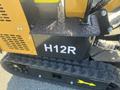 A close-up of a yellow and black 2024 AGT Mini Excavator showcasing the H12R model number and the textured surface of the track assembly