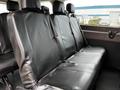 A row of black leather seats in a 2020 Ford Transit van with seatbelts and clean upholstery