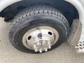 Close-up view of a tire and wheel from a 2014 Chevrolet Express featuring a shiny chrome hubcap and a rugged tread pattern on the tire