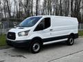 A white 2018 Ford Transit van parked with a sliding door open displaying a spacious cargo area
