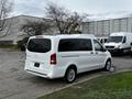 A 2018 Mercedes-Benz Metris van in white parked with sliding doors and chrome accents visible on the rear and sides