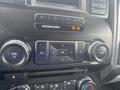 Control panel of a 2017 Ford F-550 featuring knobs for volume and tuning along with buttons for radio functions and an airbag indicator