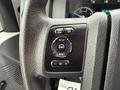 Close-up of a steering wheel button cluster from a 2011 Ford F-550 featuring controls for info setup reset and settings