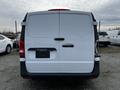 A white 2018 Mercedes-Benz Metris van viewed from the rear with a simple design featuring a split rear door and the manufacturer's logo on the back