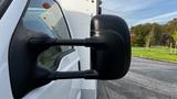 Close-up of the side mirror of a 2007 Ford F-550 showing a black plastic design with water droplets on its surface