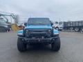 A blue 2020 Jeep Wrangler seen from the front featuring a rugged design with a prominent grille and off-road tires