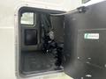 View of the open door of a 2008 International 7500 revealing the interior seating area with a black floor and a small window in the back wall