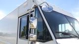 A white 2011 Ford Econoline food truck with a large window and shiny side mirrors