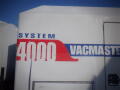 2007 Ford F-650 truck with a white exterior and red and blue lettering showing a vacuum system designation