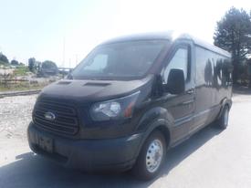 A 2016 Ford Transit van with a dark exterior and a large cargo area, featuring a distinctive front grille and large side mirrors