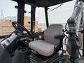 Interior view of a 2011 John Deere 310SJ 4x4 Wheel Loader with a gray seat and control panel visible