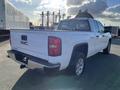 A white 2018 GMC Sierra 1500 pickup truck viewed from the rear angle showcasing its bed taillights and GMC emblem