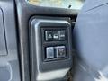 Control panel of a 2007 GMC W5500 featuring buttons for unlocking and locking along with a switch for headlights