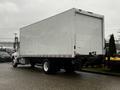 A white 2020 Hino 338 box truck with a flatbed and a large cargo area at the rear parked on a paved surface