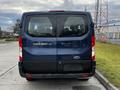 A 2020 Ford Transit van viewed from the rear with a dark blue exterior and the model name TRANSIT 150 displayed on the back