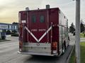 A red 1994 Freightliner FL80 fire department truck with "FIRE DEPT" written on the back and white stripes on the rear compartment