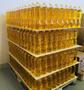 A stack of large plastic bottles filled with yellow sunflower oil arranged on pallets