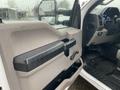 A close-up view of the interior door panel of a 2017 Ford F-250 SD featuring a black armrest and storage area with rain droplets on the window